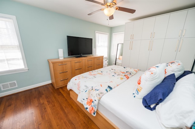 bedroom featuring a ceiling fan, baseboards, visible vents, dark wood finished floors, and a closet