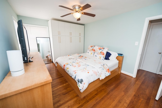 bedroom with a closet, baseboards, dark wood-type flooring, and a ceiling fan