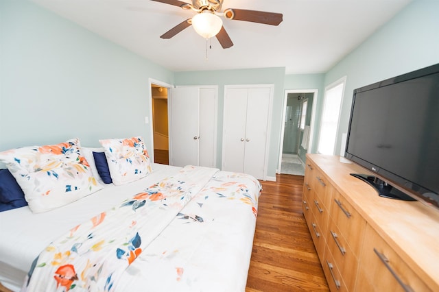 bedroom featuring light wood-style flooring, two closets, and ceiling fan