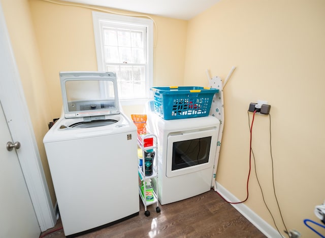 washroom with baseboards, wood finished floors, washing machine and dryer, and laundry area