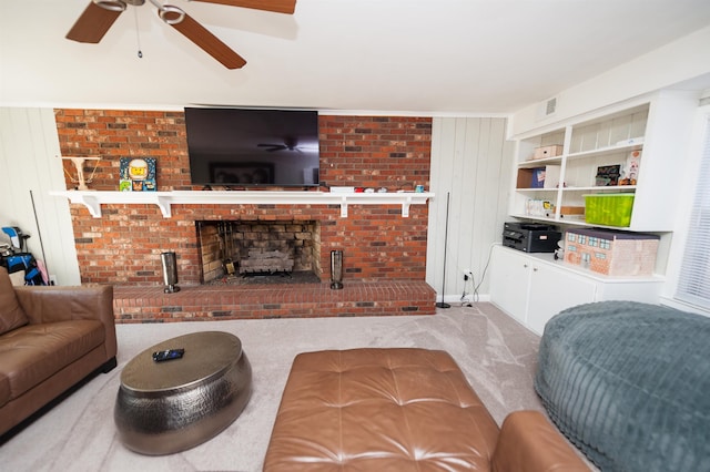 living area featuring a ceiling fan, a fireplace, visible vents, and carpet floors