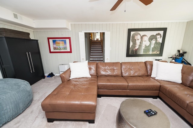 living room with stairway, visible vents, and a ceiling fan