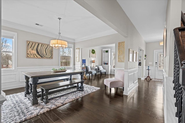 dining area with visible vents, a notable chandelier, dark wood-type flooring, ornamental molding, and wainscoting