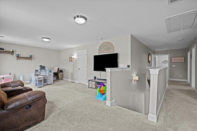 living room with attic access, carpet flooring, and baseboards