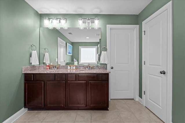 bathroom with tile patterned floors, visible vents, a sink, double vanity, and baseboards