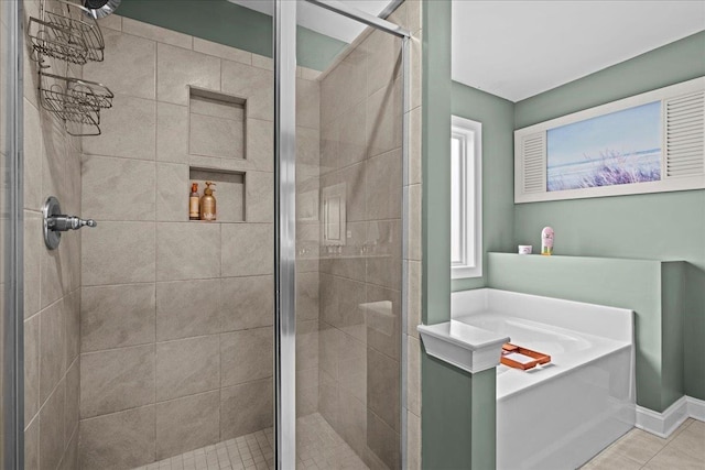 bathroom with a garden tub, tile patterned floors, baseboards, and a shower stall