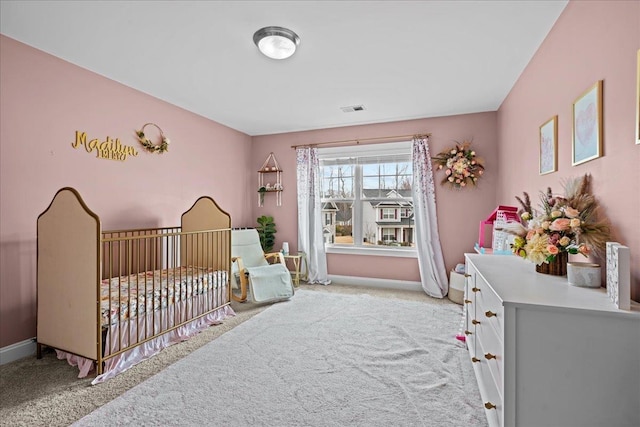 carpeted bedroom with visible vents, a nursery area, and baseboards