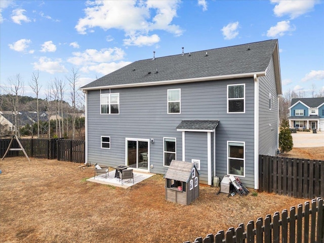 rear view of house featuring a patio, a yard, a fenced backyard, and a fire pit