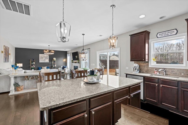 kitchen featuring open floor plan, visible vents, a chandelier, and a sink