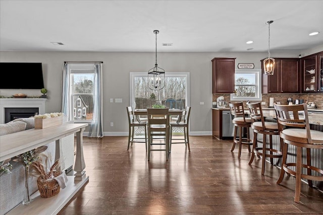 dining room with dark wood finished floors, a notable chandelier, and baseboards