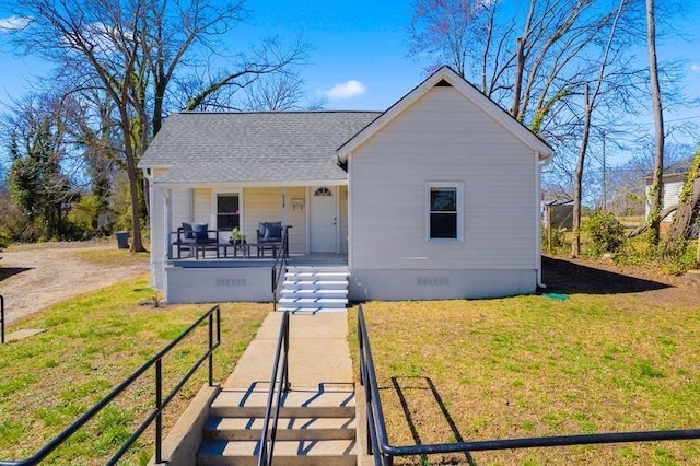 view of front of house featuring a porch, a front lawn, roof with shingles, and crawl space