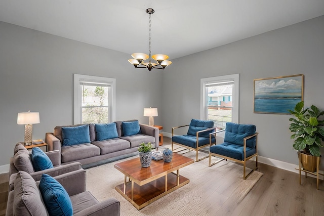 living room with baseboards, an inviting chandelier, and wood finished floors