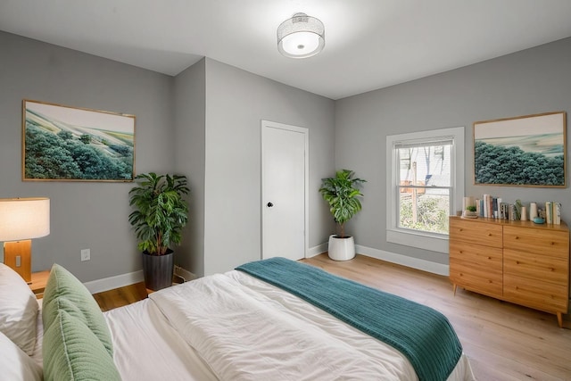 bedroom with light wood-style flooring and baseboards