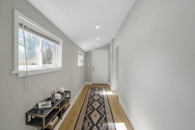 corridor with lofted ceiling, recessed lighting, light wood-type flooring, and baseboards