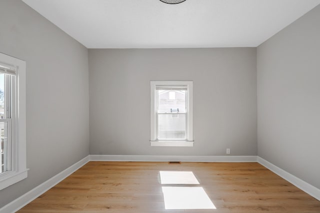 spare room with visible vents, baseboards, and light wood-type flooring