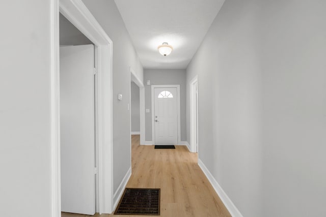 entryway featuring light wood finished floors, visible vents, and baseboards