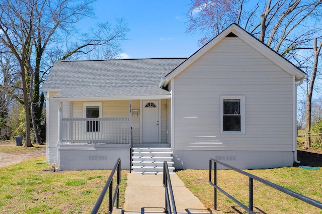 bungalow-style house featuring crawl space, covered porch, a shingled roof, and a front lawn