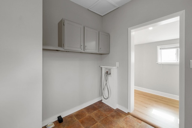 laundry area featuring baseboards, cabinet space, and washer hookup