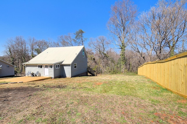 view of yard with a wooden deck, stairs, and fence