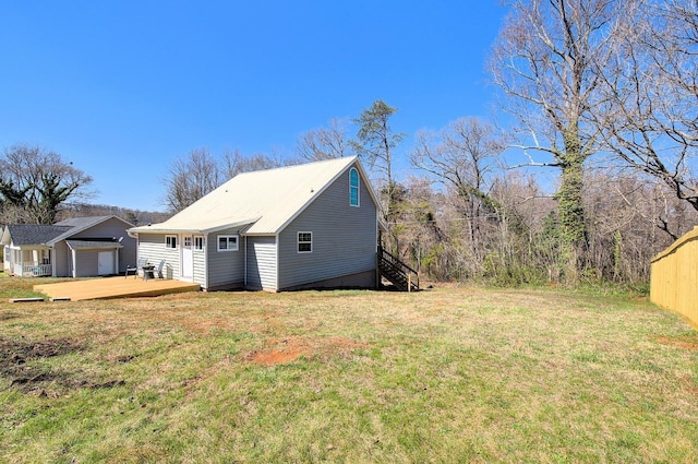 view of side of property featuring a lawn and fence