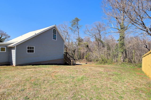 view of property exterior featuring stairs and a yard