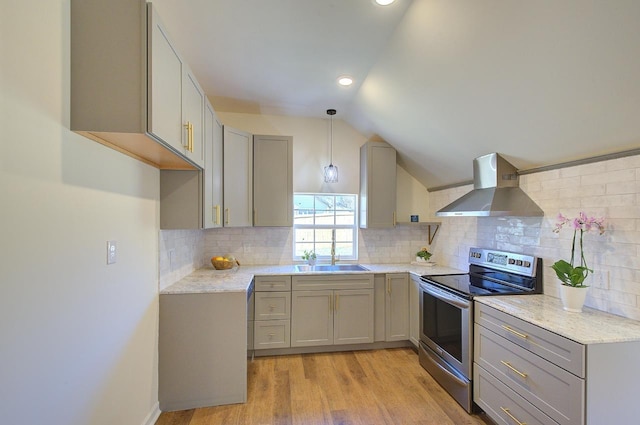 kitchen featuring gray cabinetry, wall chimney range hood, lofted ceiling, electric range, and a sink