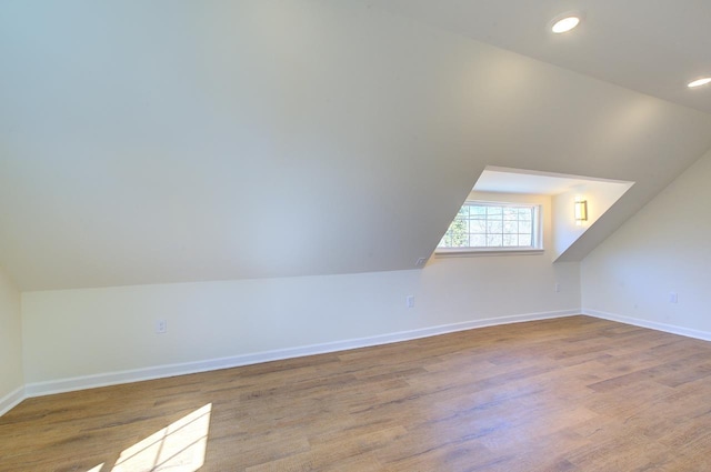 additional living space with vaulted ceiling, recessed lighting, wood finished floors, and baseboards