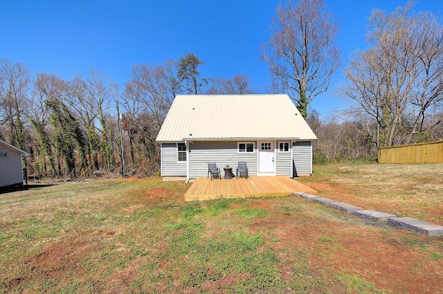 back of house featuring metal roof, a lawn, and a wooden deck