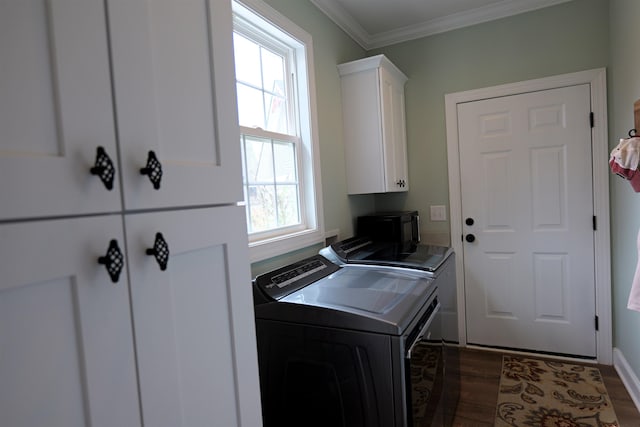 laundry area featuring cabinet space, dark wood-style floors, washing machine and dryer, and crown molding