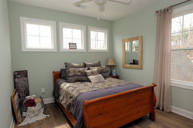 bedroom with dark wood-type flooring, visible vents, baseboards, and ceiling fan