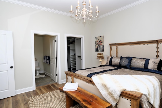 bedroom featuring wood finished floors, a chandelier, a spacious closet, and ornamental molding