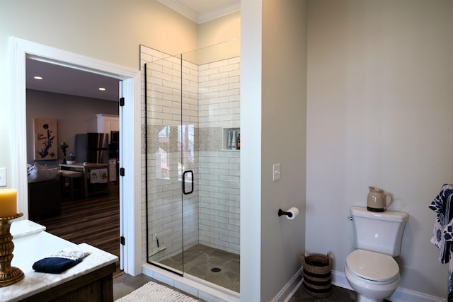 full bath featuring a stall shower, toilet, baseboards, and ornamental molding