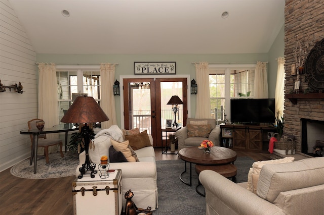 living room with a wealth of natural light, french doors, dark wood finished floors, and a fireplace