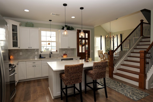 kitchen featuring visible vents, a sink, dark wood finished floors, light countertops, and a chandelier