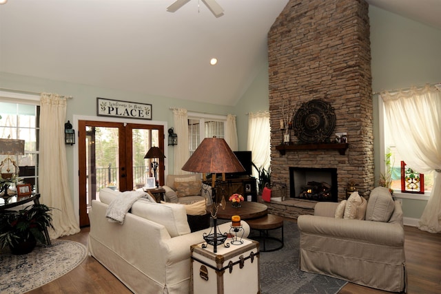 living area with ceiling fan, french doors, a stone fireplace, and wood finished floors