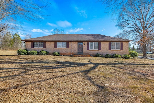 ranch-style home featuring brick siding and a front yard