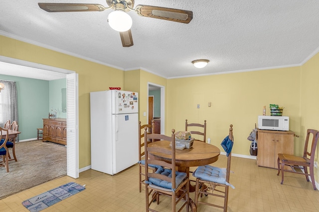 dining area featuring light floors, baseboards, ceiling fan, a textured ceiling, and crown molding