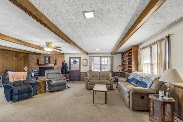 living room featuring beamed ceiling, wooden walls, carpet floors, and a textured ceiling