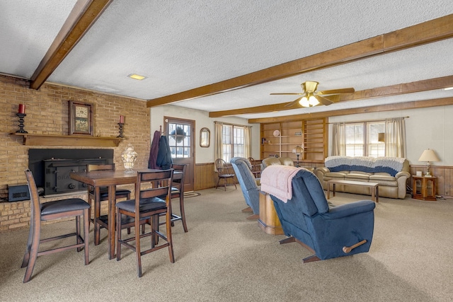 dining space with beam ceiling, wainscoting, and a textured ceiling