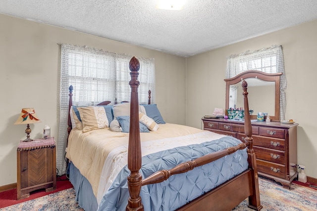 bedroom featuring multiple windows, carpet floors, and a textured ceiling