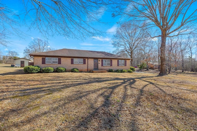 ranch-style house featuring brick siding and a front lawn