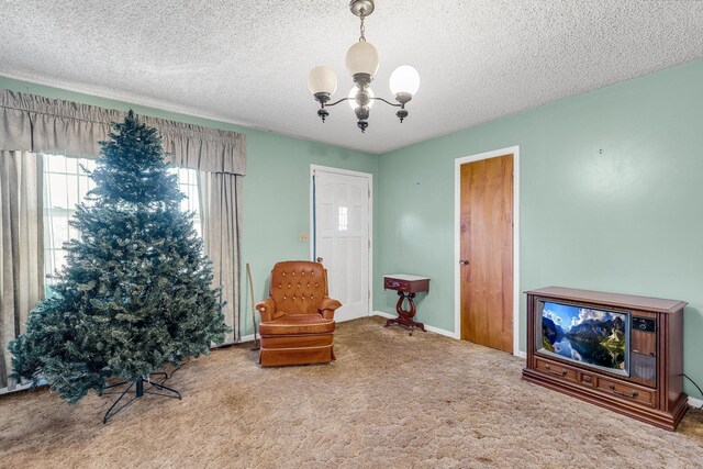 sitting room with a notable chandelier, baseboards, carpet floors, and a textured ceiling