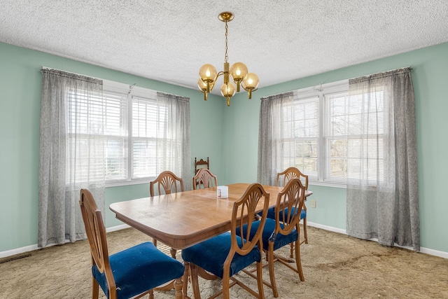 carpeted dining room featuring baseboards, a notable chandelier, and a textured ceiling