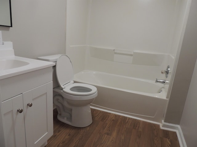 bathroom featuring toilet, vanity, shower / bathing tub combination, and wood finished floors