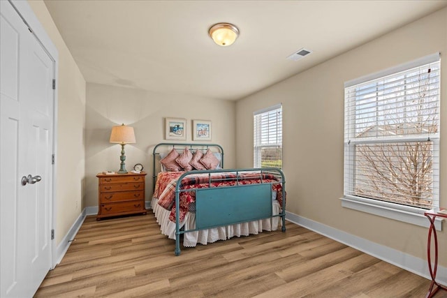 bedroom featuring visible vents, baseboards, and light wood-style floors