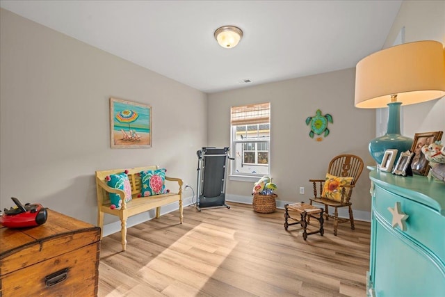 sitting room featuring light wood-style floors, visible vents, and baseboards