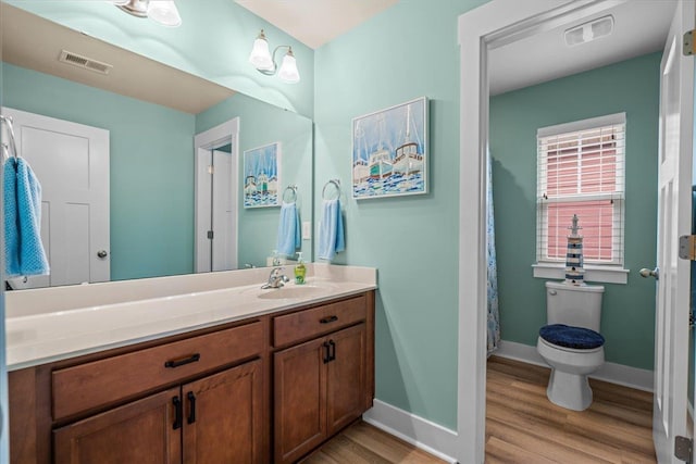 full bathroom with visible vents, vanity, baseboards, and wood finished floors