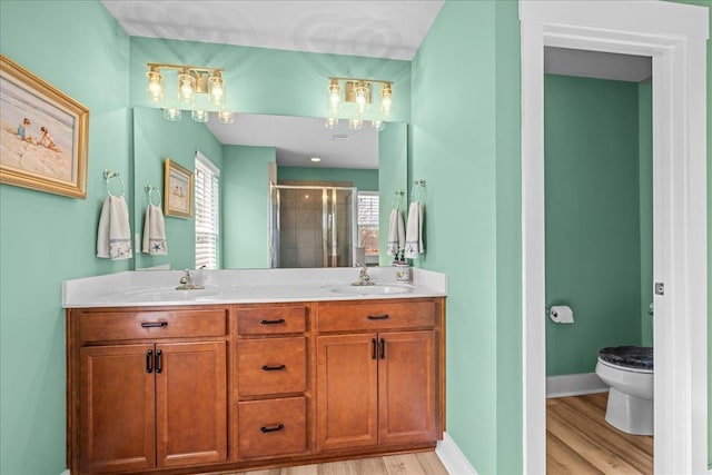 full bath featuring toilet, baseboards, a stall shower, and a sink