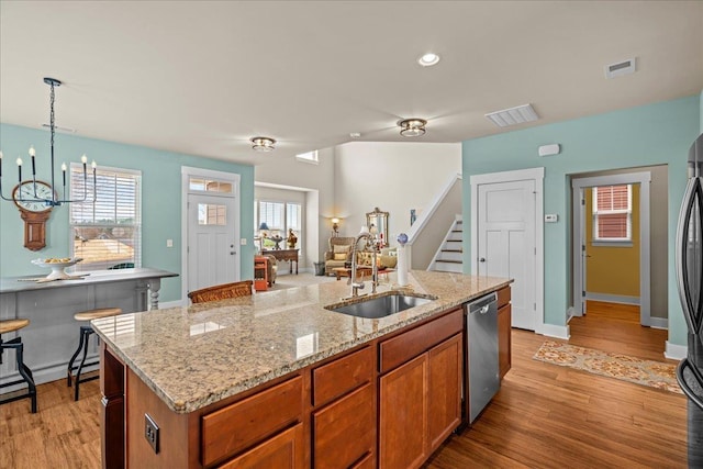 kitchen with visible vents, light wood-style flooring, dishwasher, and a sink