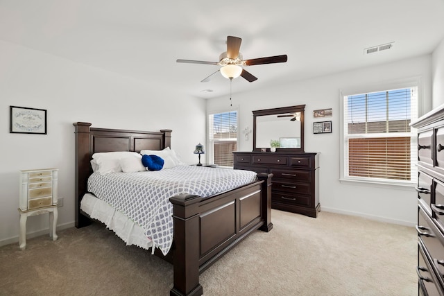 bedroom with light carpet, visible vents, multiple windows, and baseboards